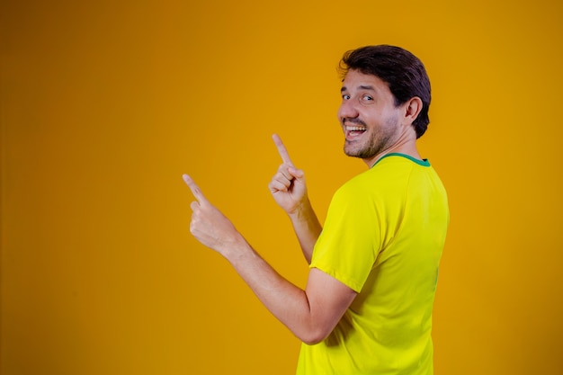 Homem brasileiro com blusa brasileira com retrovisor apontando para o lado