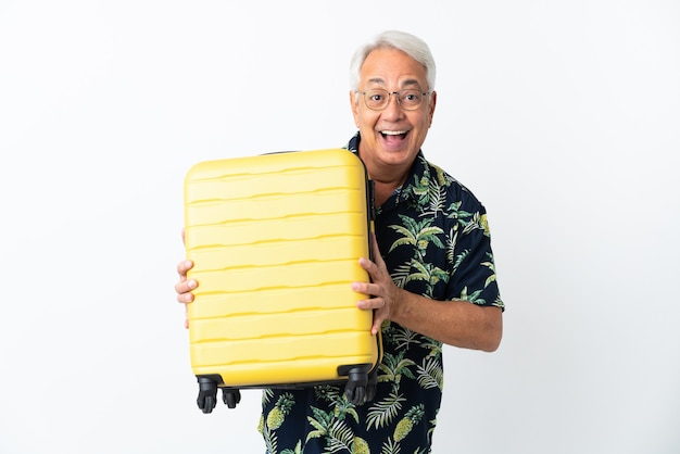 Homem brasileiro de meia-idade isolado no fundo branco em férias com mala de viagem e surpreso
