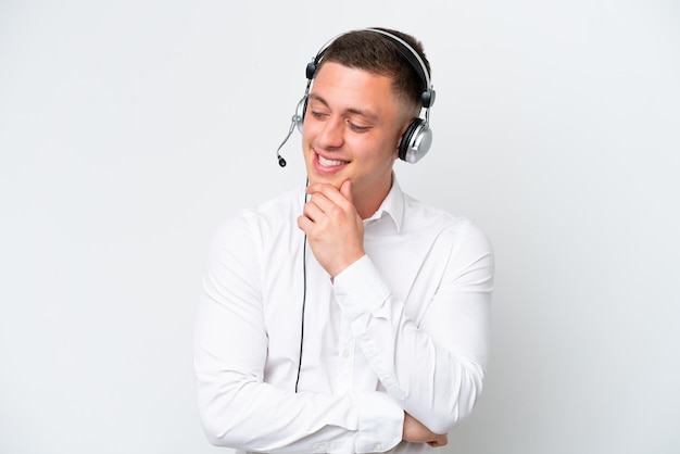 Homem brasileiro de telemarketing trabalhando com um fone de ouvido isolado no fundo branco, olhando para o lado