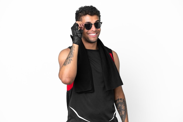 Homem brasileiro esportivo com toalha isolada no fundo branco com óculos e feliz