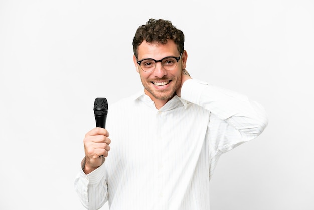 Homem brasileiro pegando um microfone sobre fundo branco isolado rindo