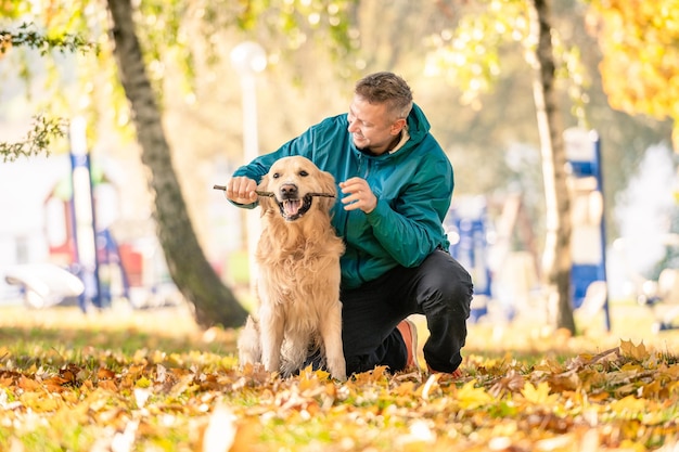 Homem brincando com seu cachorro golden retriever no parque