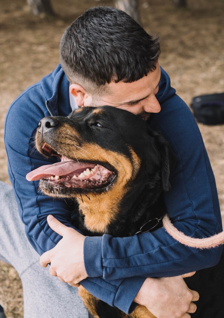 Foto homem brincando com seu cachorro rottweiler no parque