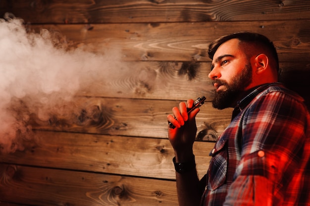 Homem brutal fumando cigarro eletrônico