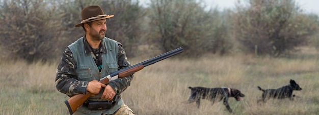 Foto homem caçador camuflado com uma arma durante a caça em busca de pássaros selvagens ou de caça