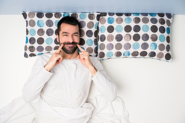 Homem, cama, em, vista superior, sorrindo, com, um, feliz, e, agradável, expressão