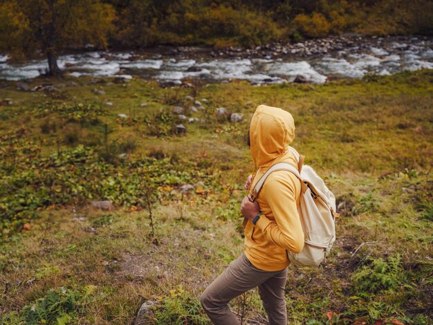 Foto homem caminha pelas montanhas com mochila de viagem conceito de aventura de estilo de vida errante férias de outono ao ar livre sozinho na natureza viagem ao cáucaso do norte arkhyz rússia