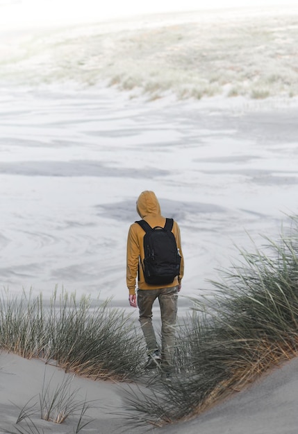 homem caminha sobre dunas de areia na Dinamarca