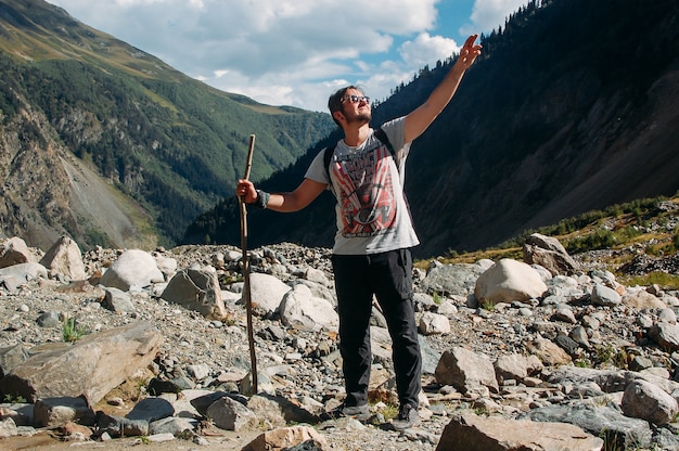 Homem caminhadas mostrando a direção com a mão em pé nas montanhas em Svaneti na Geórgia