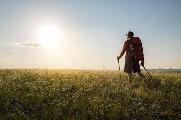 Homem caminhando ao pôr do sol