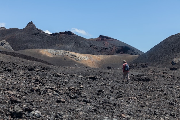 Homem caminhando na paisagem do campo de lava