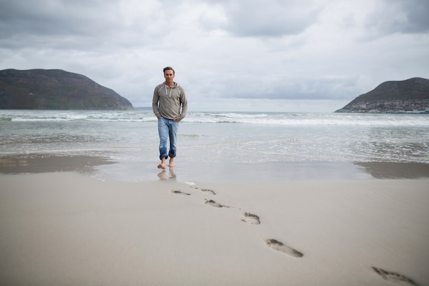 Homem caminhando na praia