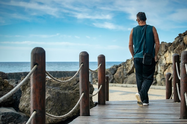 Homem caminhando na praia