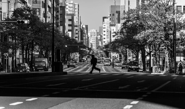 Homem caminhando na rua em meio a edifícios na cidade