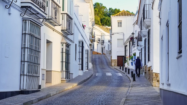 Homem caminhando pelas ruas estreitas da vila branca e pitoresca de Medina Sidonia Cadiz