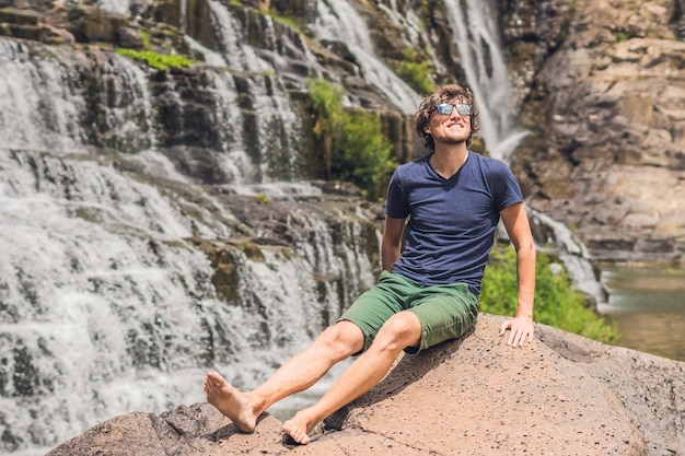 Homem caminhante e turista na superfície da incrível cachoeira Pongour é famosa e a mais bonita do outono no Vietnã