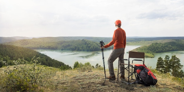 Homem caminhante relaxando no topo da montanha e desfrutando da vista do vale com o lago Banner com espaço de cópia