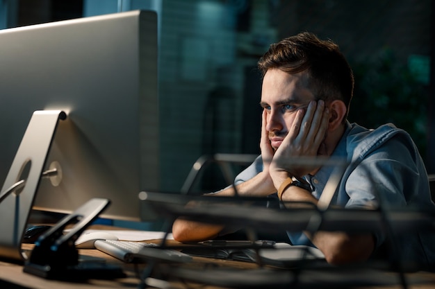 Foto homem cansado no computador no escritório