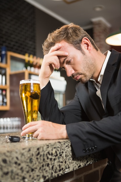 Homem cansado, tomando uma cerveja