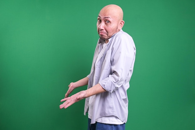 Foto homem careca agitando confuso e mostrando um gesto de impotência encolhendo o ombro