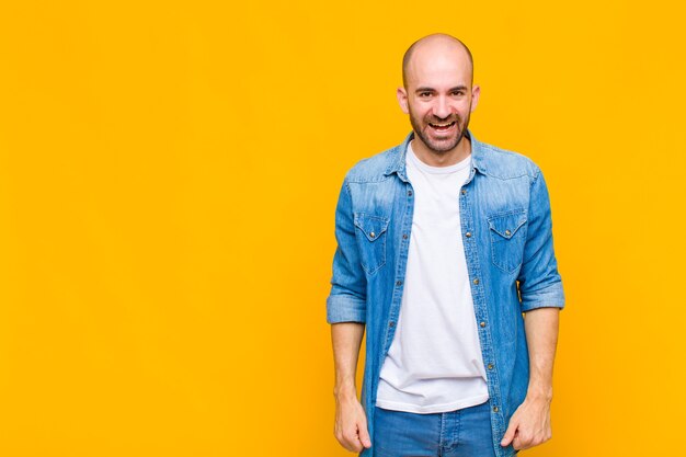 Homem careca com um sorriso grande, amigável e despreocupado, parecendo positivo, relaxado e feliz, arrepiante