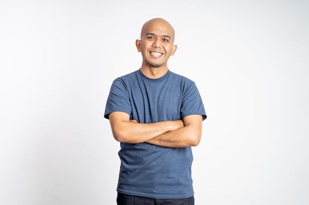 Homem careca feliz em camiseta com os braços cruzados