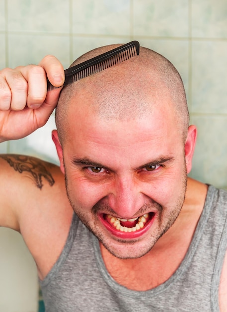 Foto homem careca louco penteia o cabelo