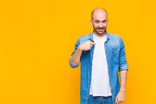 Homem careca parecendo feliz, orgulhoso e surpreso, apontando alegremente para si mesmo, sentindo-se confiante e altivo