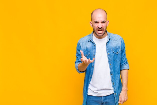 Homem careca parecendo zangado, irritado e frustrado gritando wtf ou o que há de errado com você