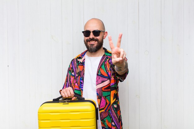 Homem careca sorrindo e parecendo feliz, despreocupado e positivo, gesticulando vitória ou paz com uma das mãos