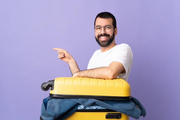 Homem carregando bagagem sobre fundo roxo isolado