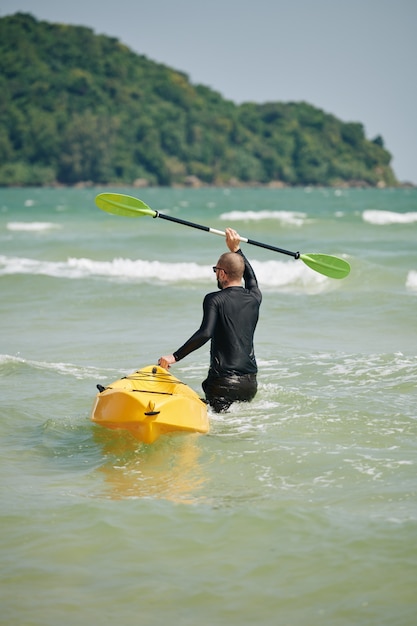 Homem carregando barco caiaque