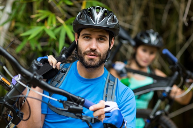 Homem carregando bicicleta de montanha