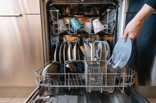 Homem carregando máquina de lavar louça na cozinha em casa