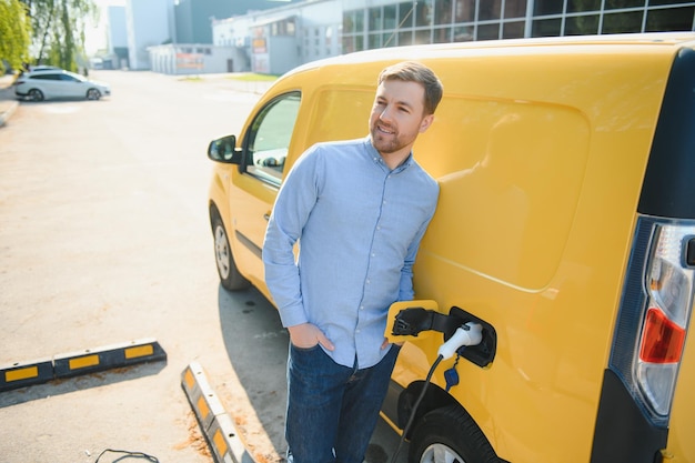 Homem carregando seu carro elétrico na estação de recarga