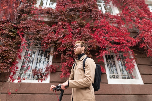 Foto homem casual andando de scooter ao ar livre