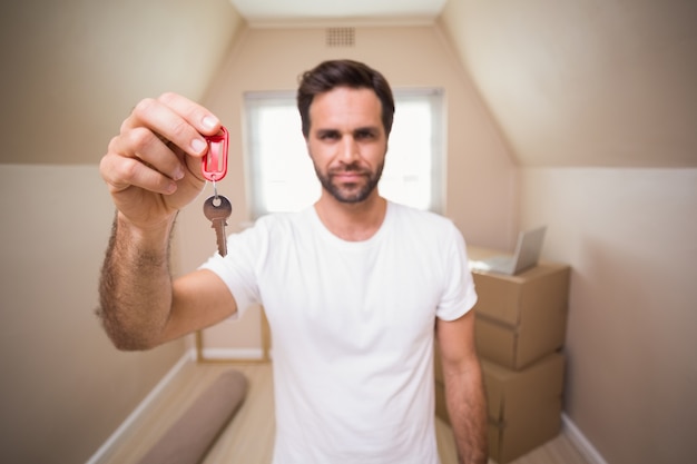 Foto homem casual mostrando a chave da sua casa