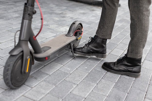 Homem casual posando com sua scooter elétrica