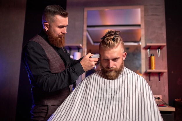 Homem caucasiano bonito no cabeleireiro na barbearia