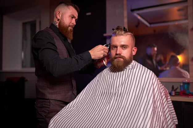 Homem caucasiano bonito no cabeleireiro na barbearia