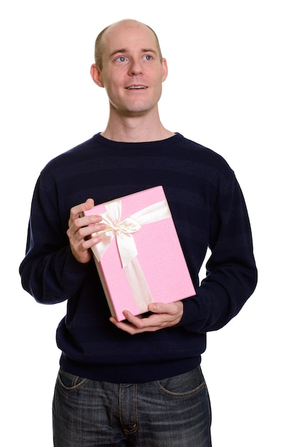 Homem caucasiano careca feliz e pensativo, sorrindo e segurando uma caixa de presente