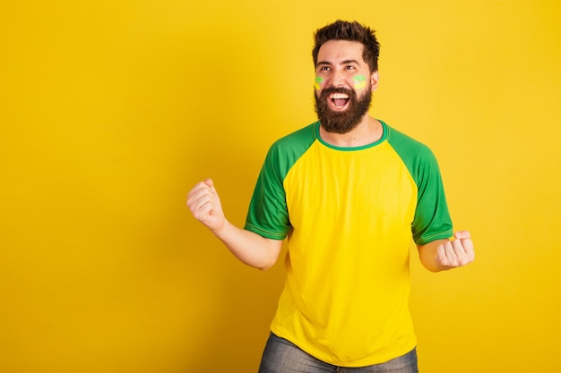 Homem caucasiano com barba fã de futebol brasileiro do brasil comemorando sim uau vitória