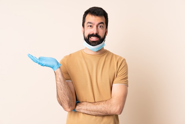 Homem caucasiano com barba, protegendo com uma máscara e luvas por cima da parede, tendo dúvidas