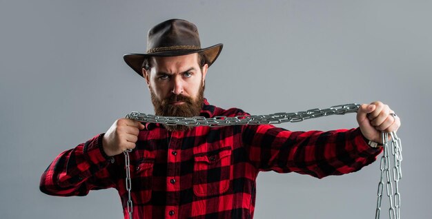 Homem caucasiano com poderosa corrente de metal nas mãos homem bonito com barba segura conceito de liberdade homem acorrentado problemas libertação da escravidão carisma masculino perfeito