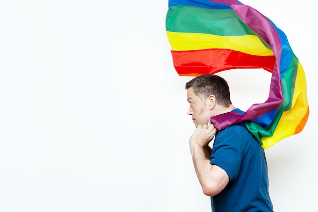 Homem caucasiano de 40 anos vestindo uma bandeira de arco-íris gay como capa