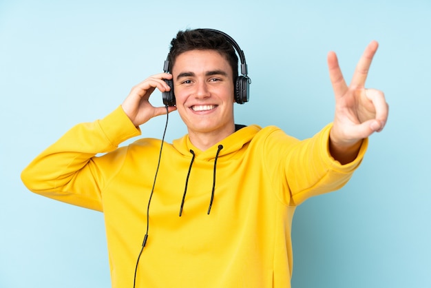 Homem caucasiano de adolescente na parede roxa, ouvir música e cantar