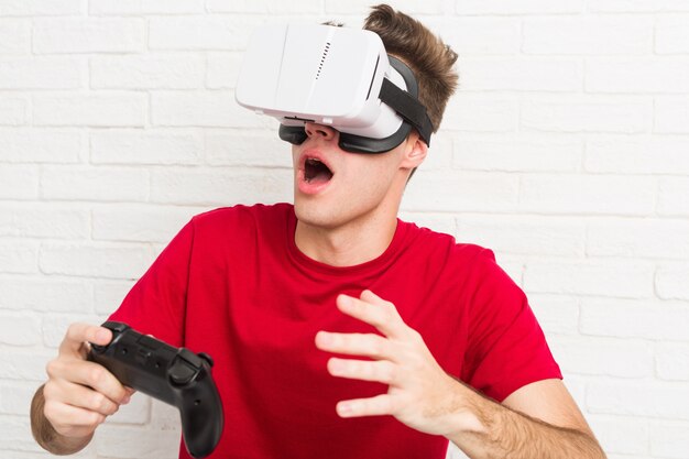 Homem caucasiano de adolescente usando óculos de realidade virtual e controlador de jogo