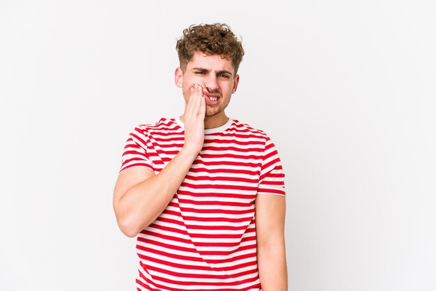 Homem caucasiano de cabelo loiro encaracolado jovem tendo uma dor de dentes forte, dor molar.