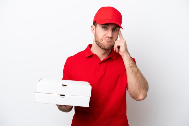 Homem caucasiano de entrega de pizza com uniforme de trabalho pegando caixas de pizza isoladas em fundo branco pensando em uma ideia