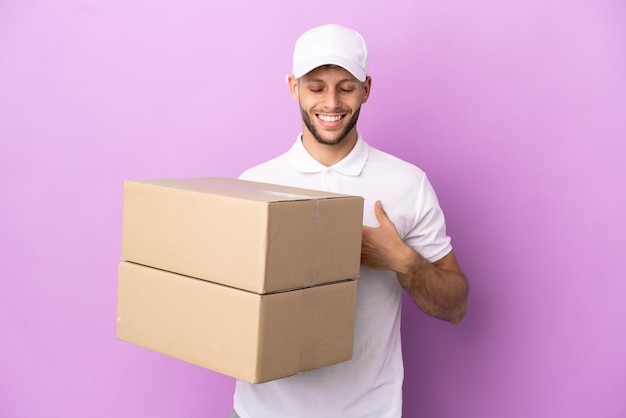 Homem caucasiano de entrega isolado no fundo roxo sorrindo muito